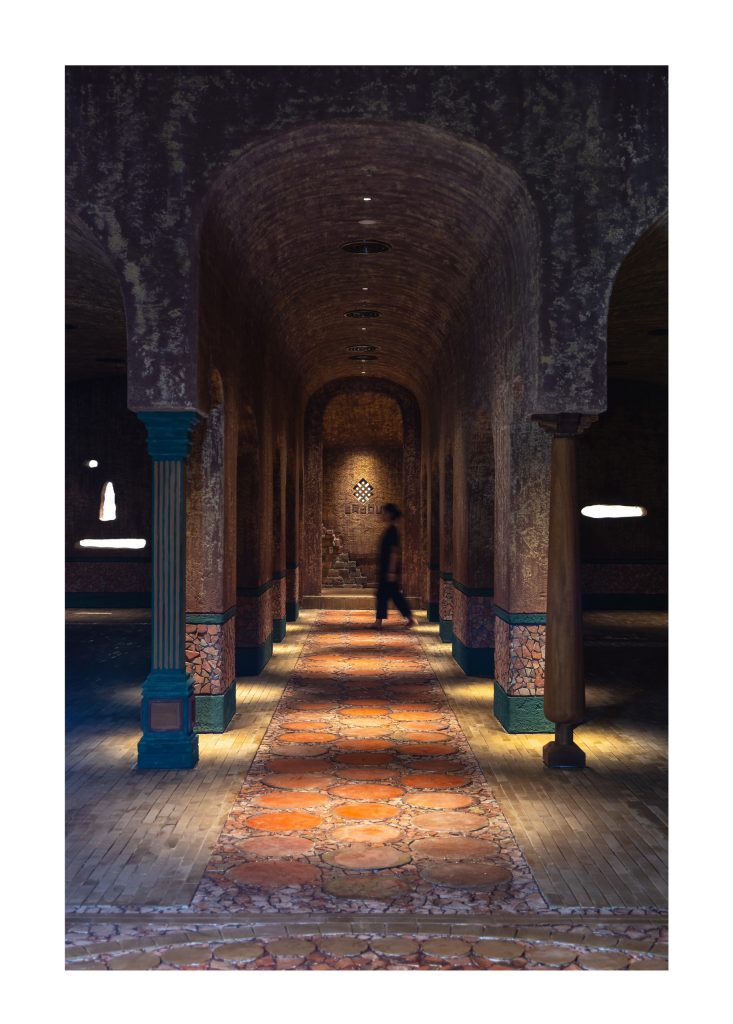 Gallery of arches with a lit niche at the end