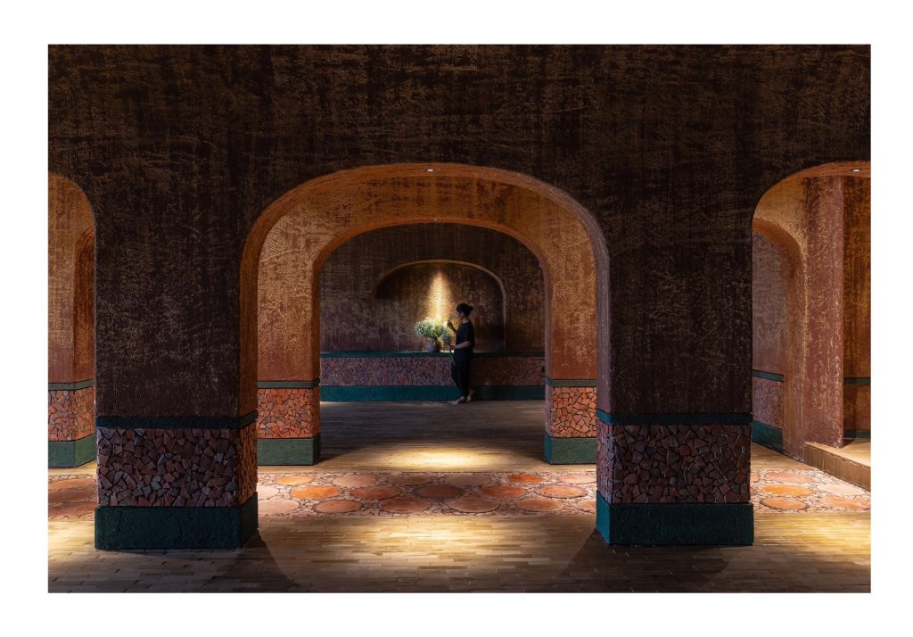 Sequence of arches leading to a lit alcove