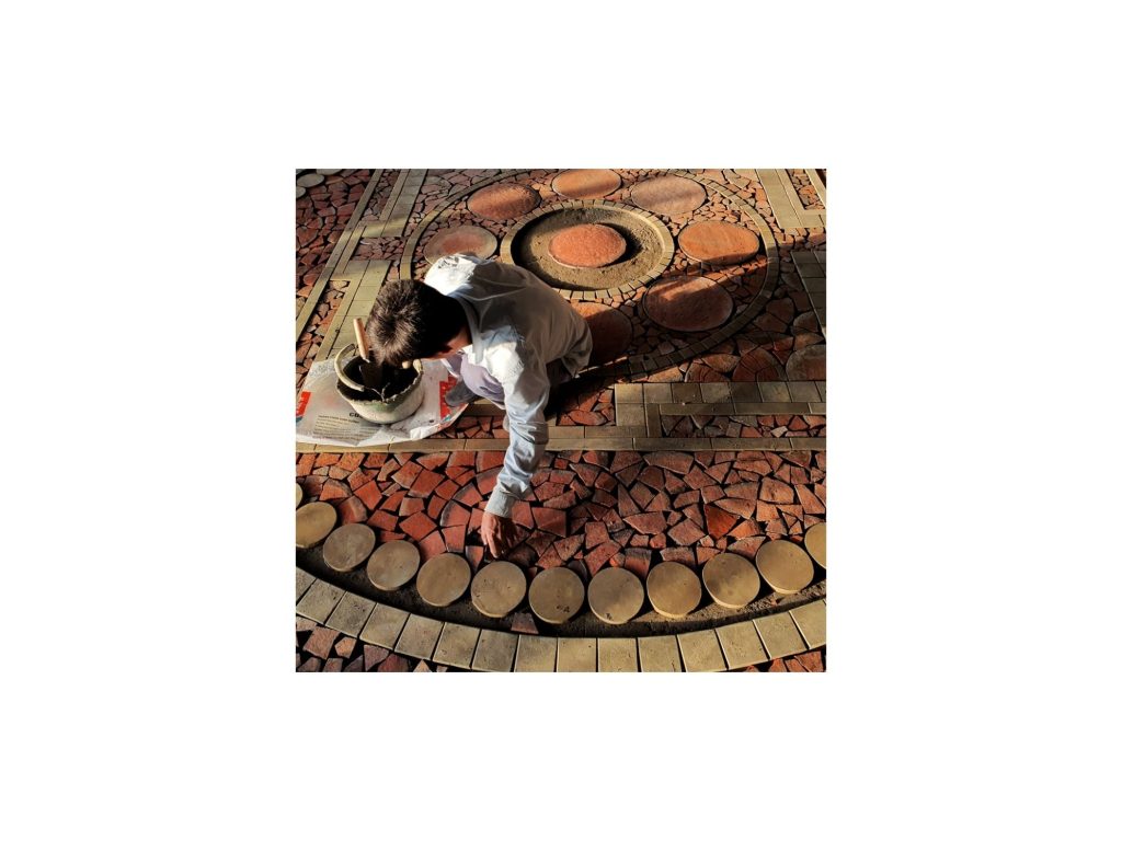 A craftsman laying terracotta discs into the floor
