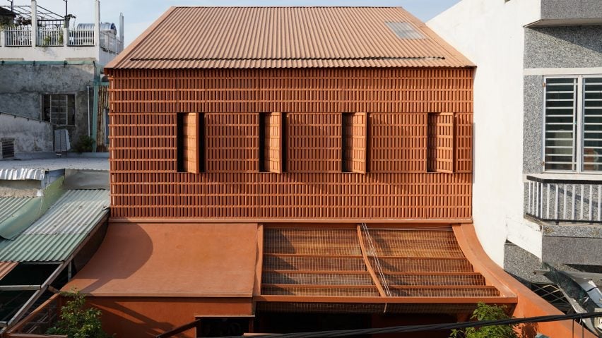 Terracotta Breath street facade with perforated brickwork and pivoting shutters