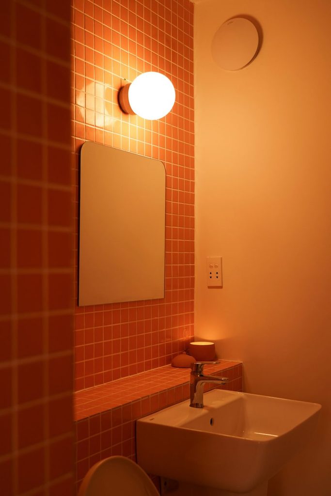 Bathroom basin beside small terracotta-coloured tiles