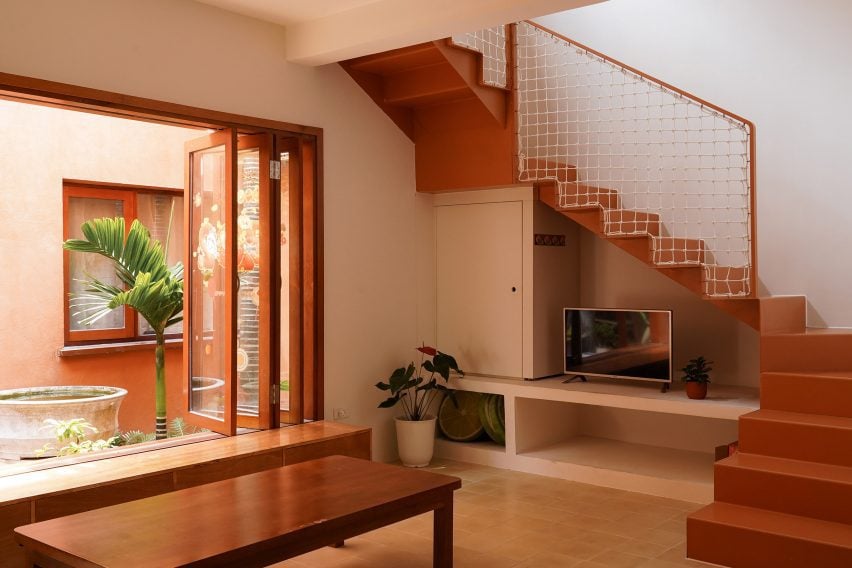 Rear living room with a steel staircase and courtyard window