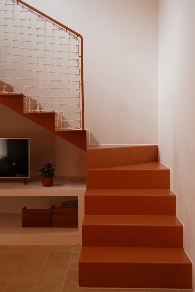 Painted steel staircase with a knotted rope balustrade