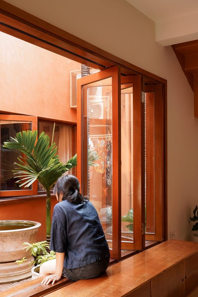 Window seat beneath folding timber-framed glazing