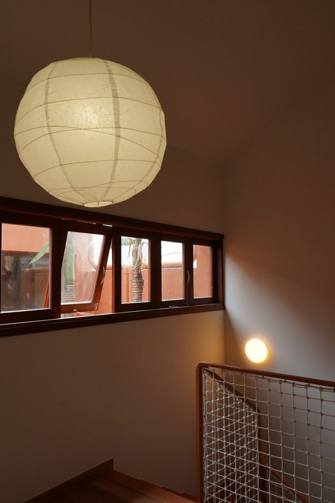 Upper stairwell with a rope balustrade and high windows