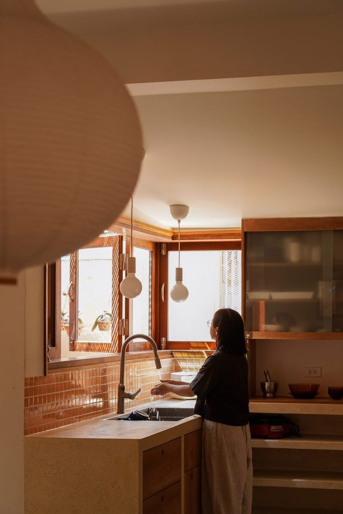 Kitchen sink and timber cabinets beside a courtyard window