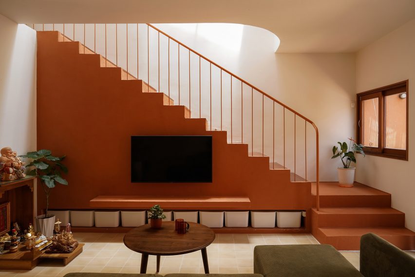 Terracotta-coloured staircase above the living room seating