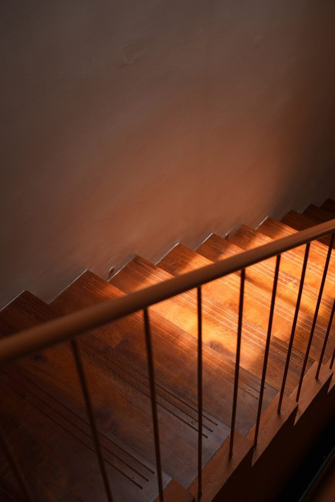 Sunlight on timber stair treads and a slender metal railing