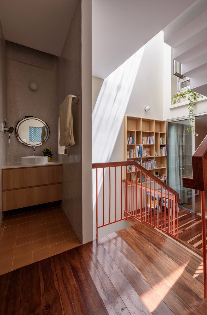Washbasin beside a bright stairwell and upper landing