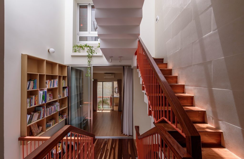 Family landing with a bookshelf, glazed doors and timber stairs