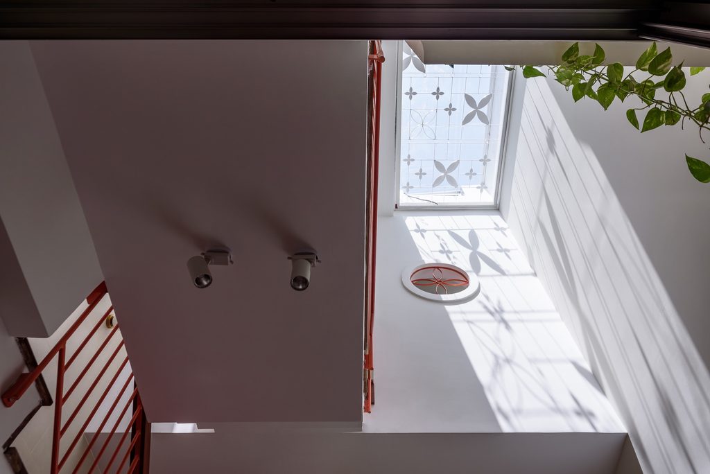 Sunlight passes through patterned roof glazing into the tall interior