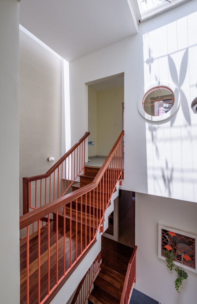 Upper stair landing with timber treads and red metal railings