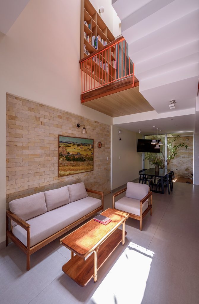 Living room with timber furnishings below the upper family landing