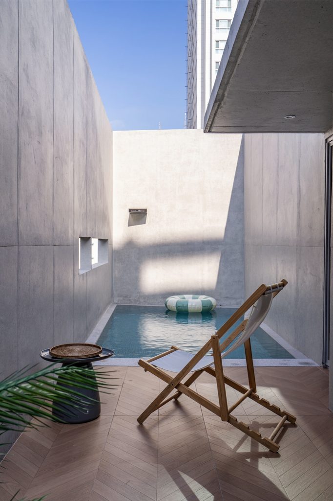 Open-air pool beside a timber deck chair