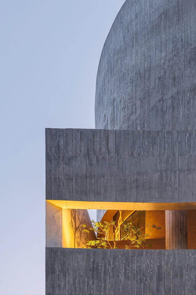 Illuminated window beneath curved concrete walls