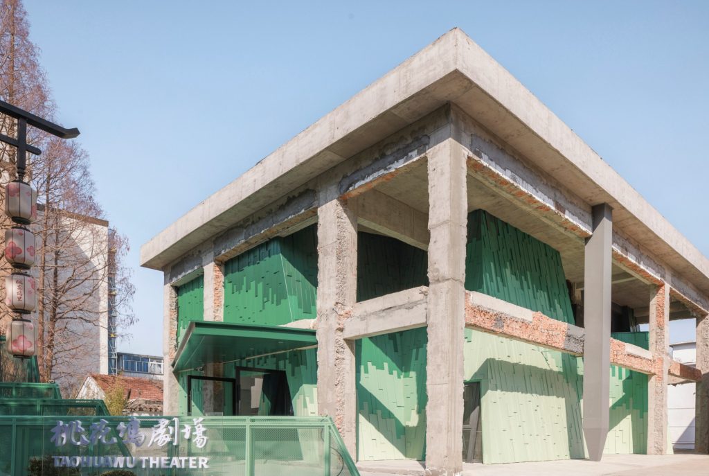 Corner of the building with green panels and concrete frame