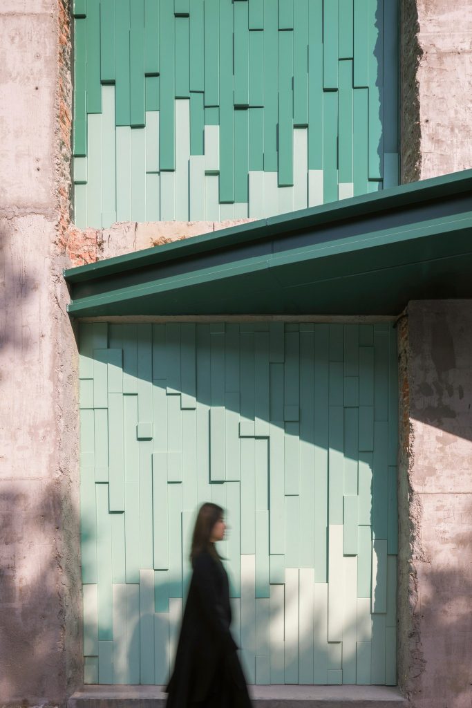 A visitor passing the panelled wall