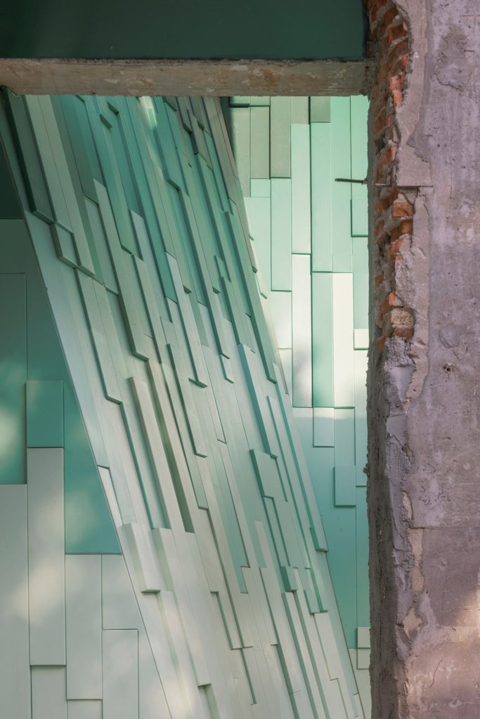 Leaning green wall beside a concrete column