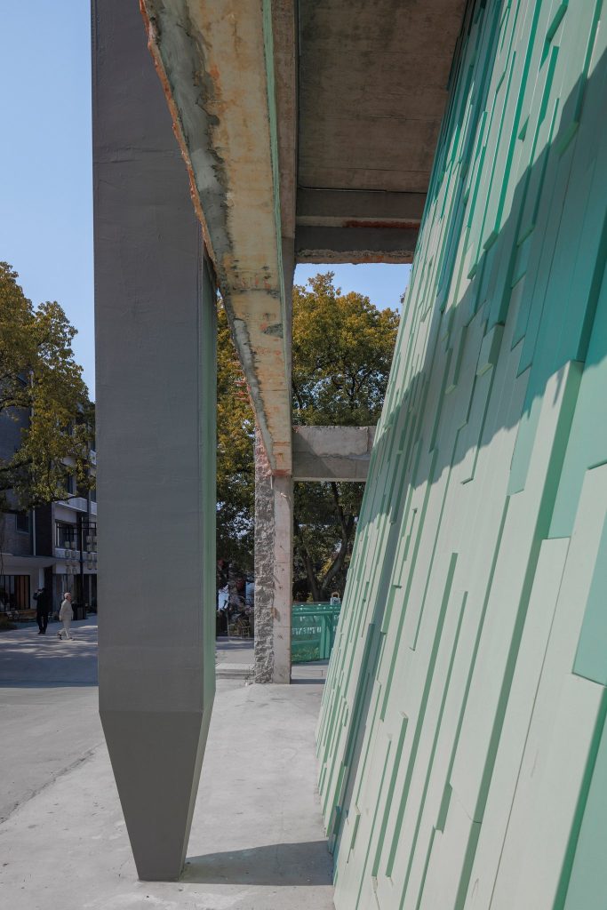 The brush-shaped column beside the green wall