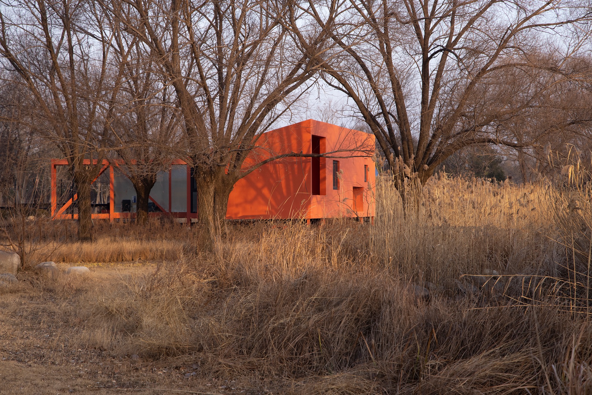 Wiki World designs red timber cabin as bridge across water in Zhengzhou
