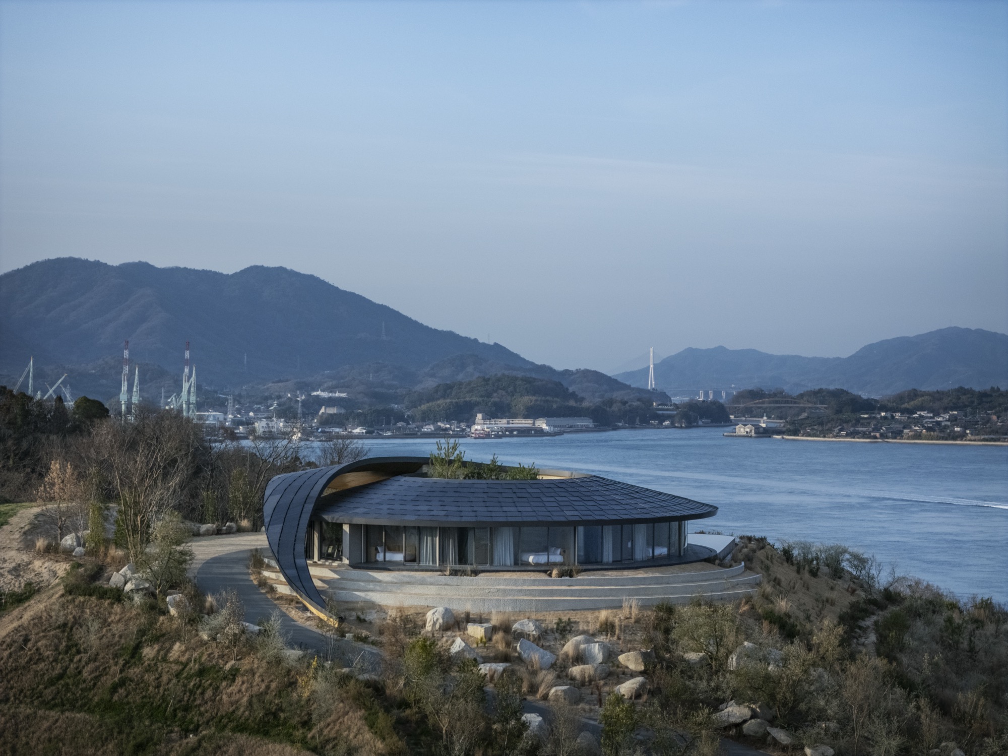 BIG carves rammed earth villas into japan’s setouchi hillside for NOT A HOTEL