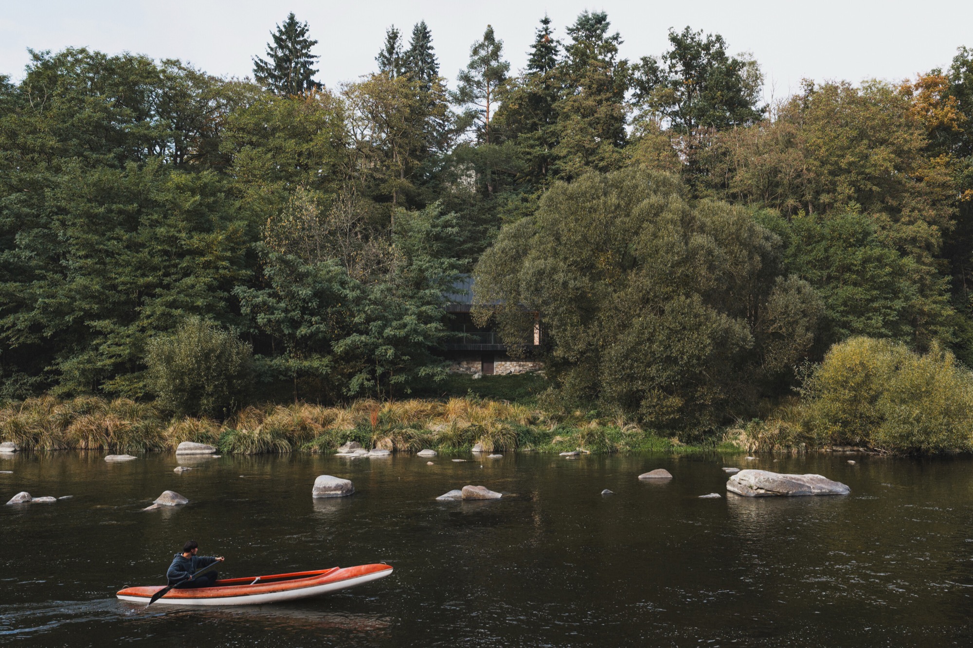A charred timber cabin overlooking the Sázava river and cliffs