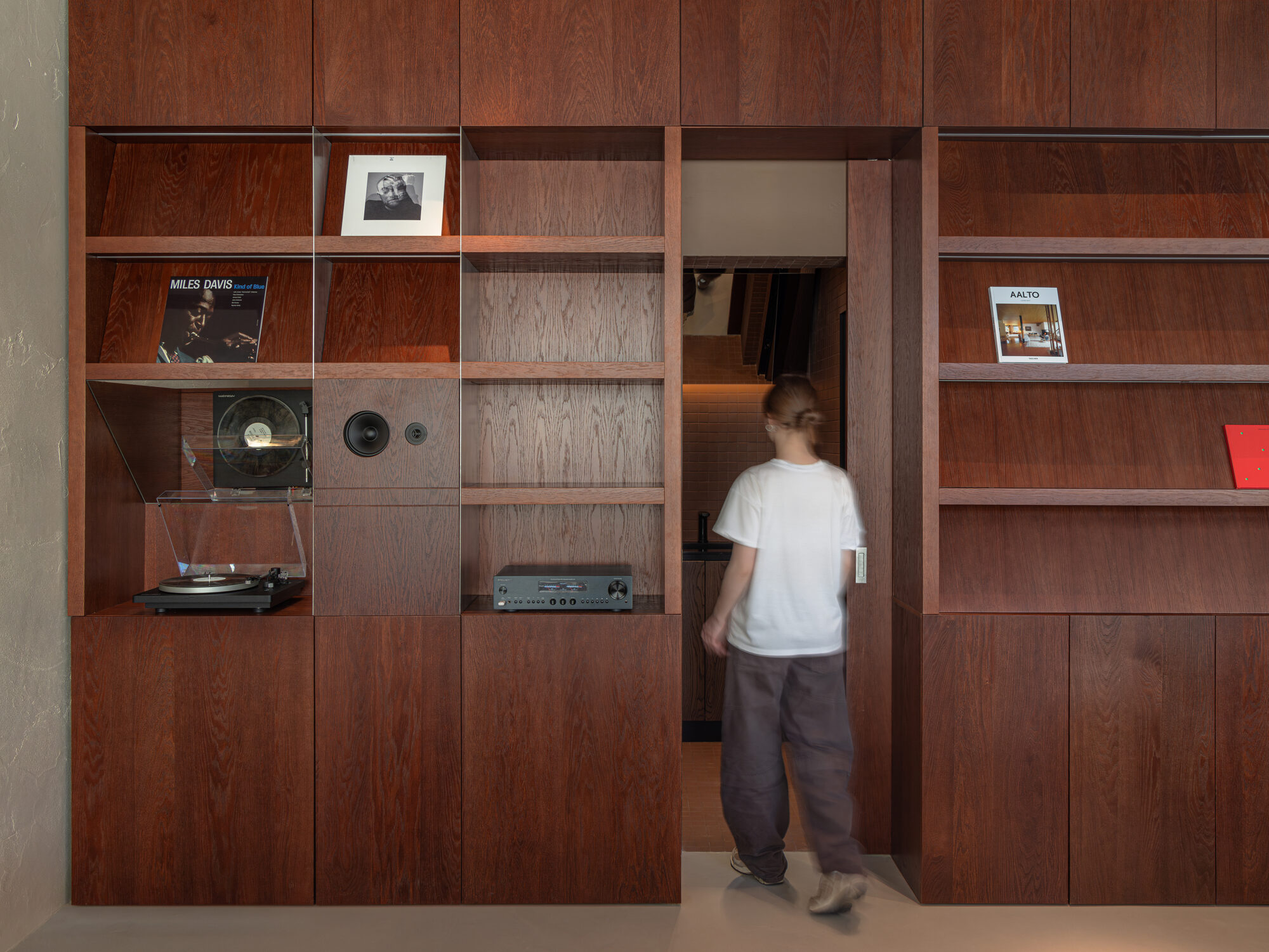 Kidz studio conceals sliding door within wall of books and records at Russian café