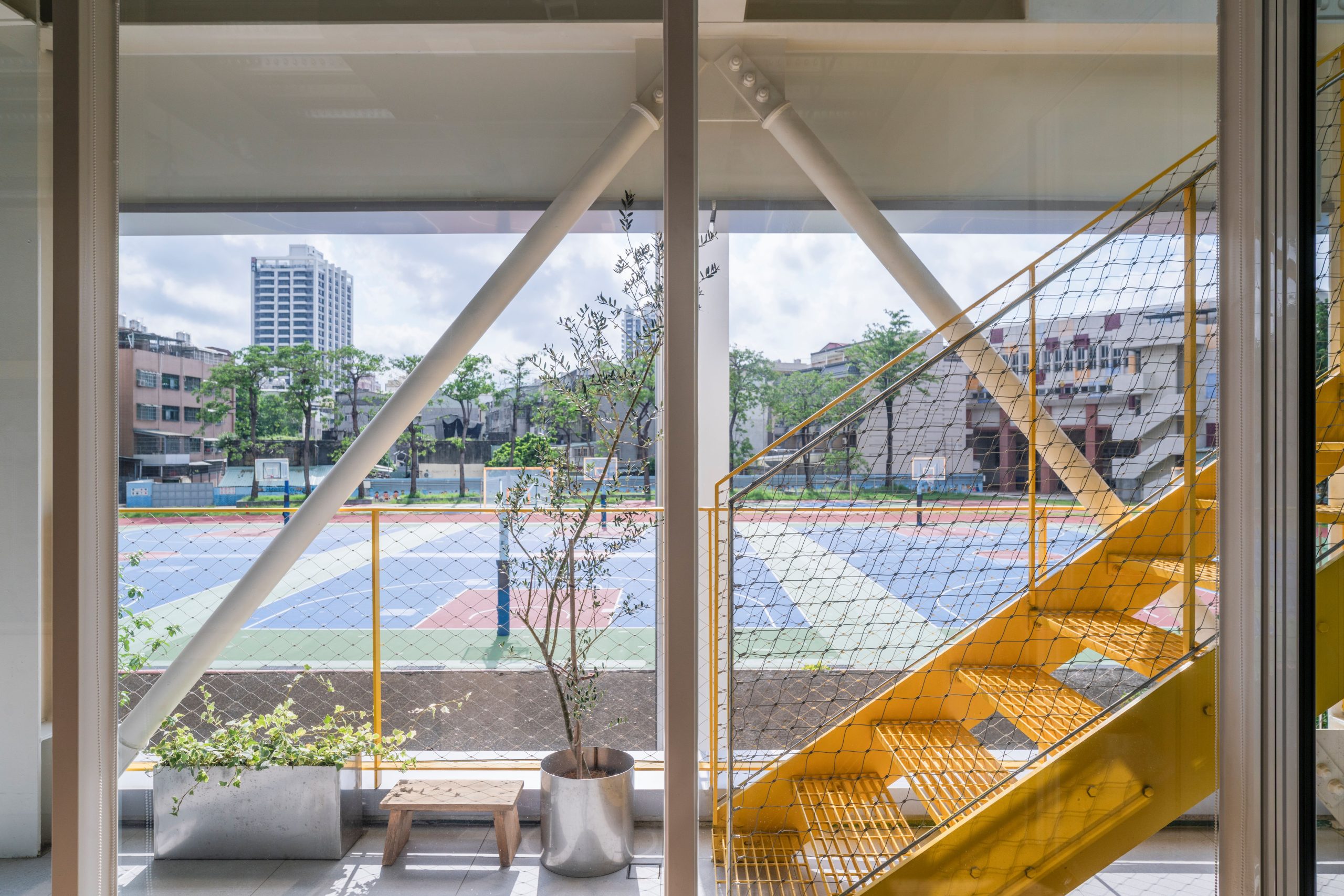 Yellow stair inside MOM House overlooking the adjacent sports field