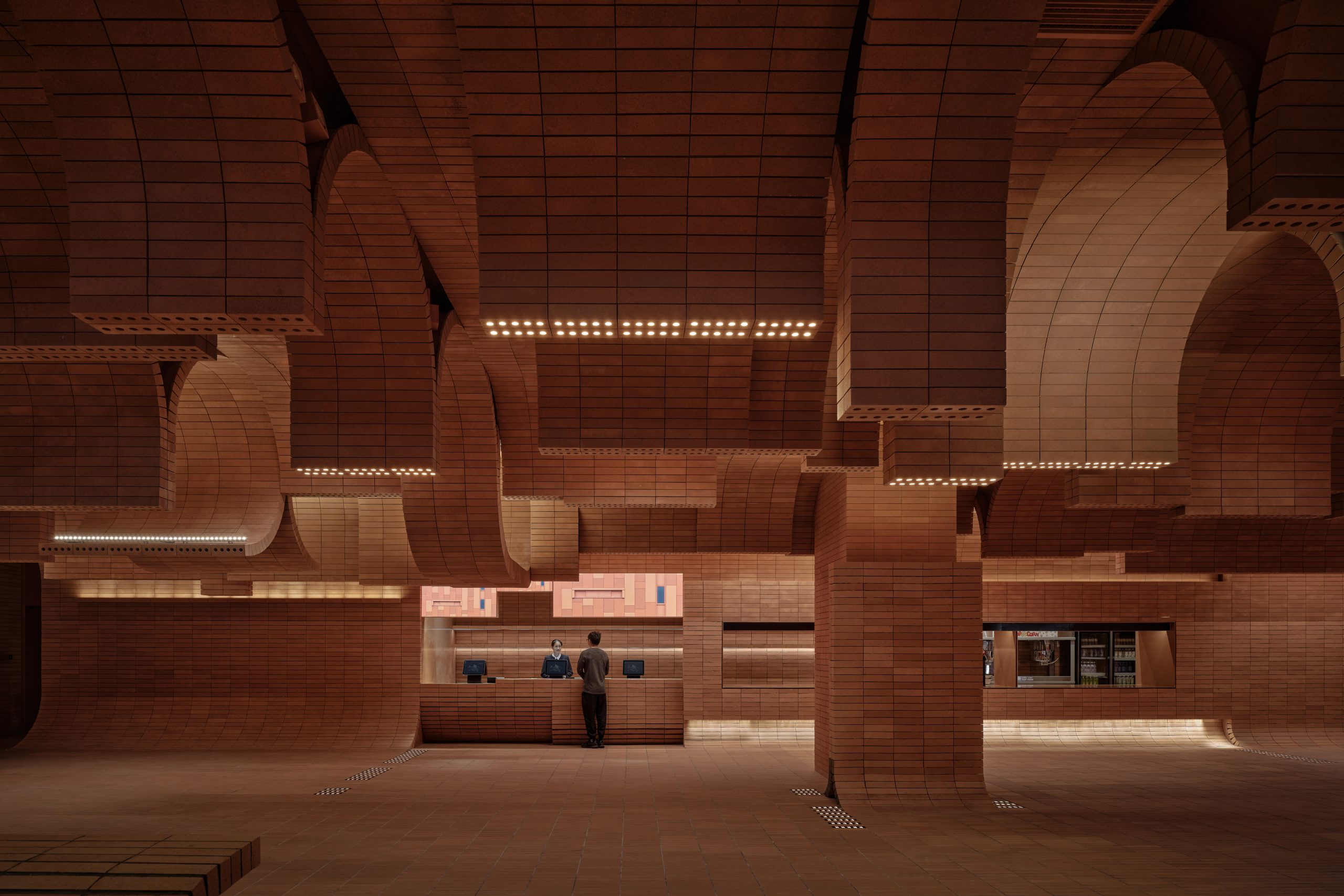 Curved seating and brick surfaces at Haikou Gaoxingli Insun Cinema