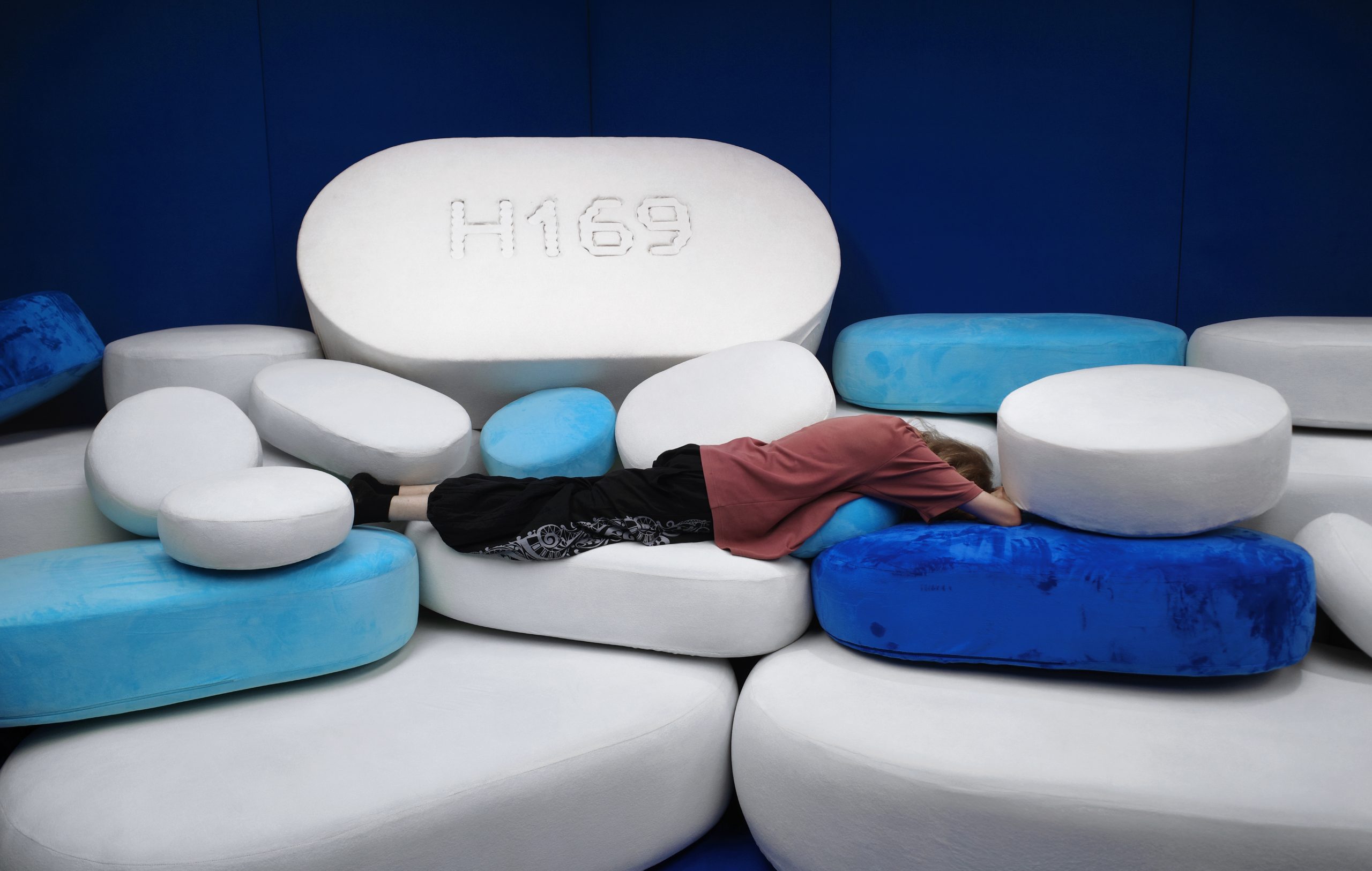 Visitors resting among the pill-shaped forms of PiLLOW.