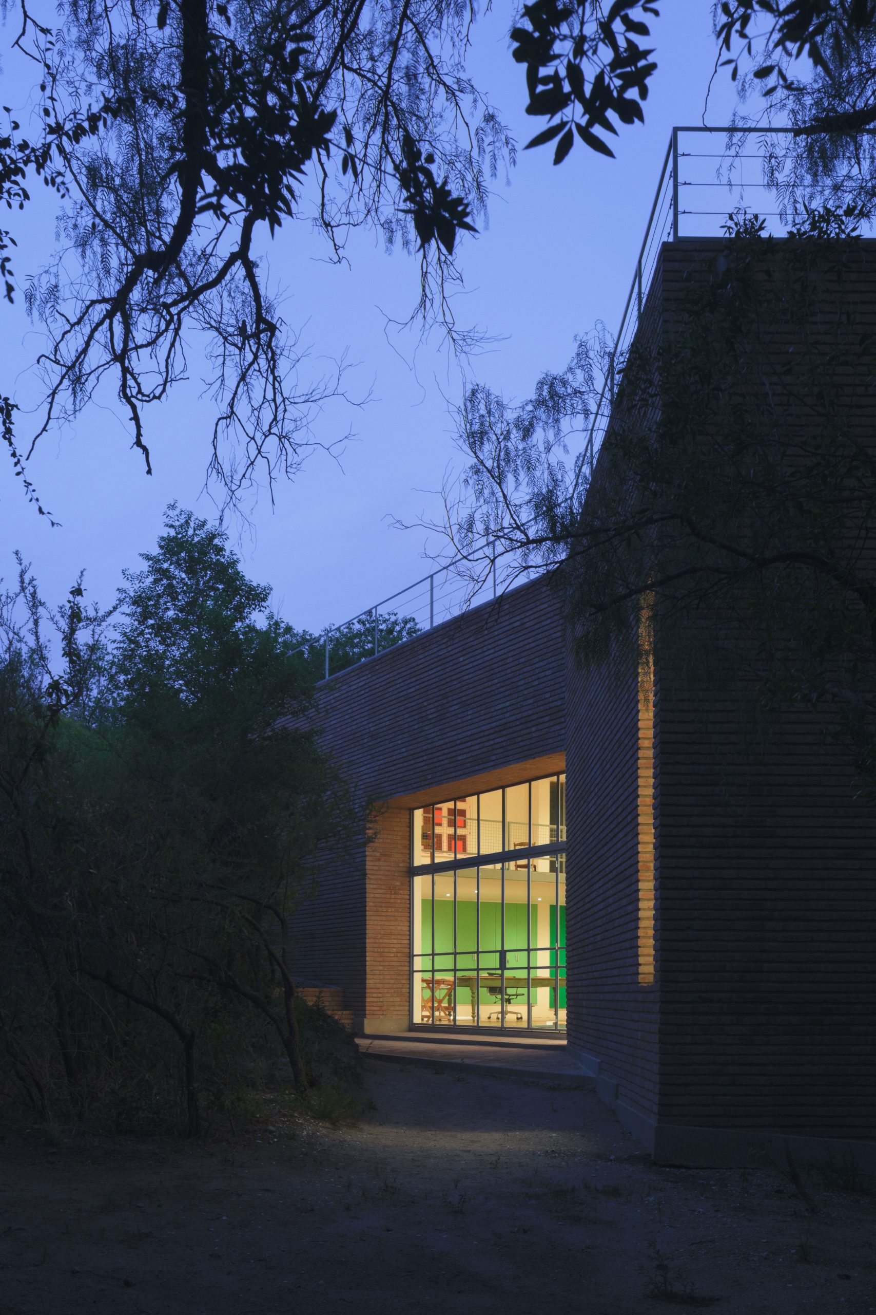 Exposed brick exterior of Atelier Cambre among native trees