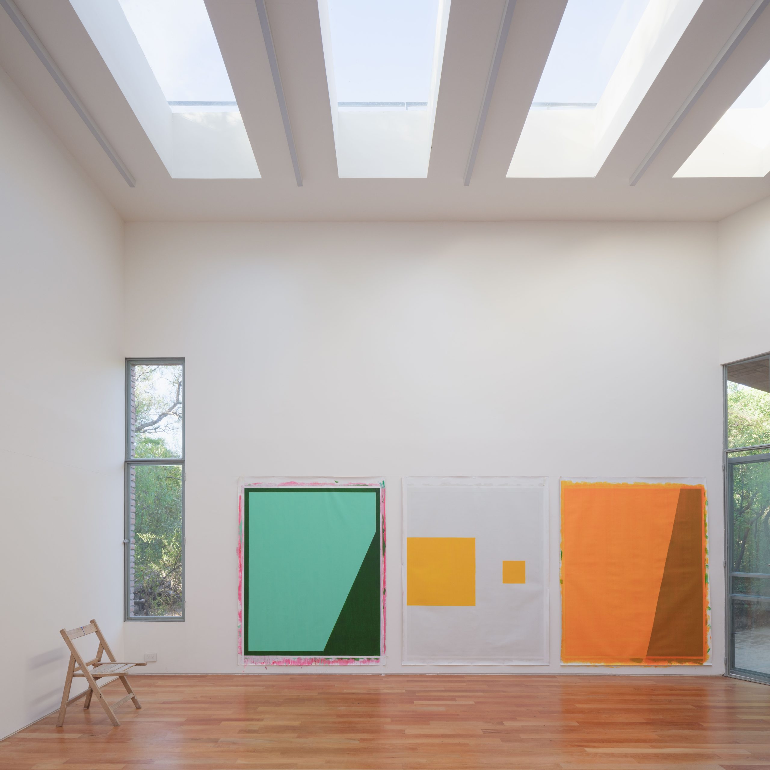 Double-height artist studio with white walls and zenithal light