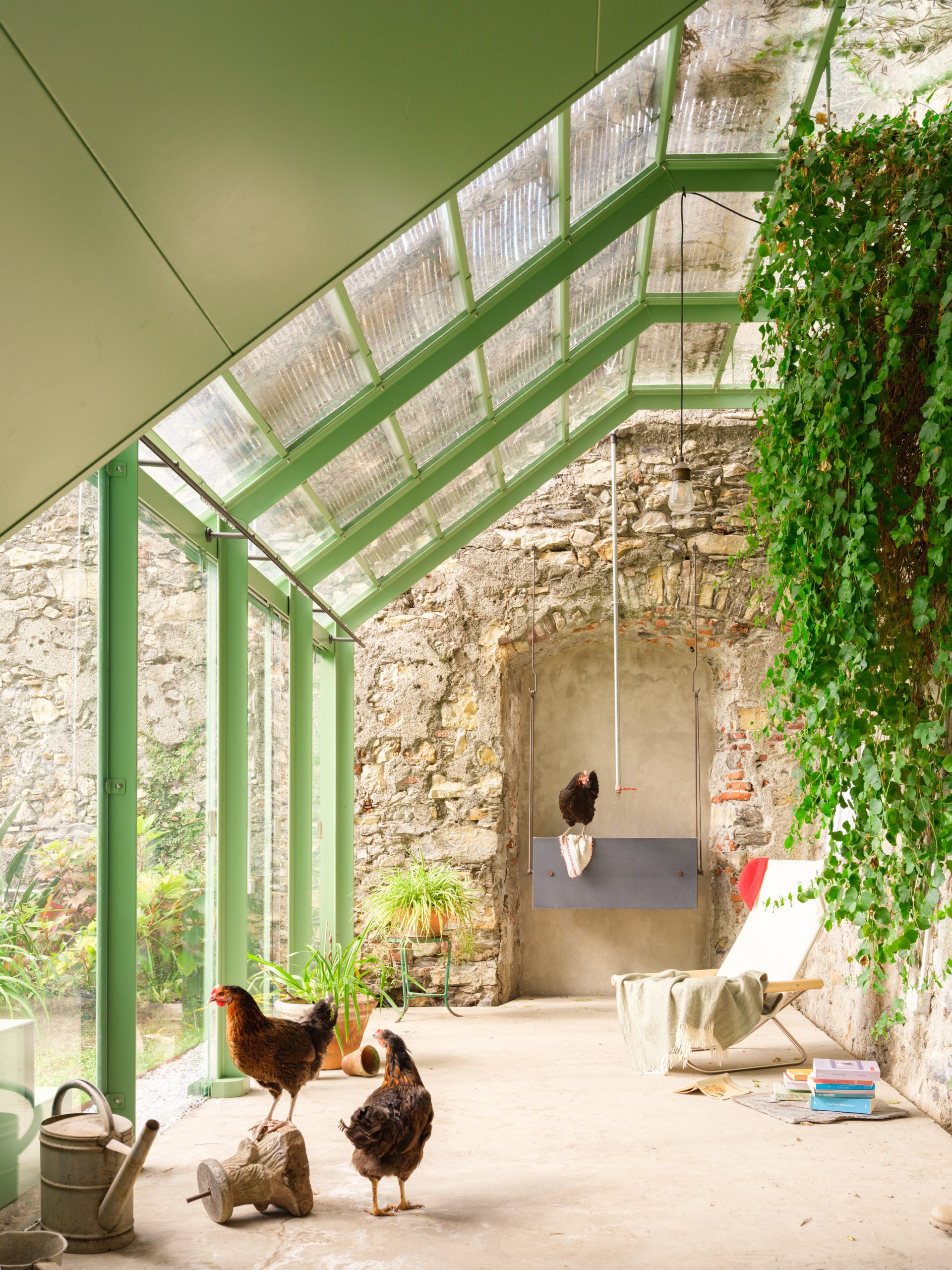 Pistachio-green steel structure meeting the historic garden wall