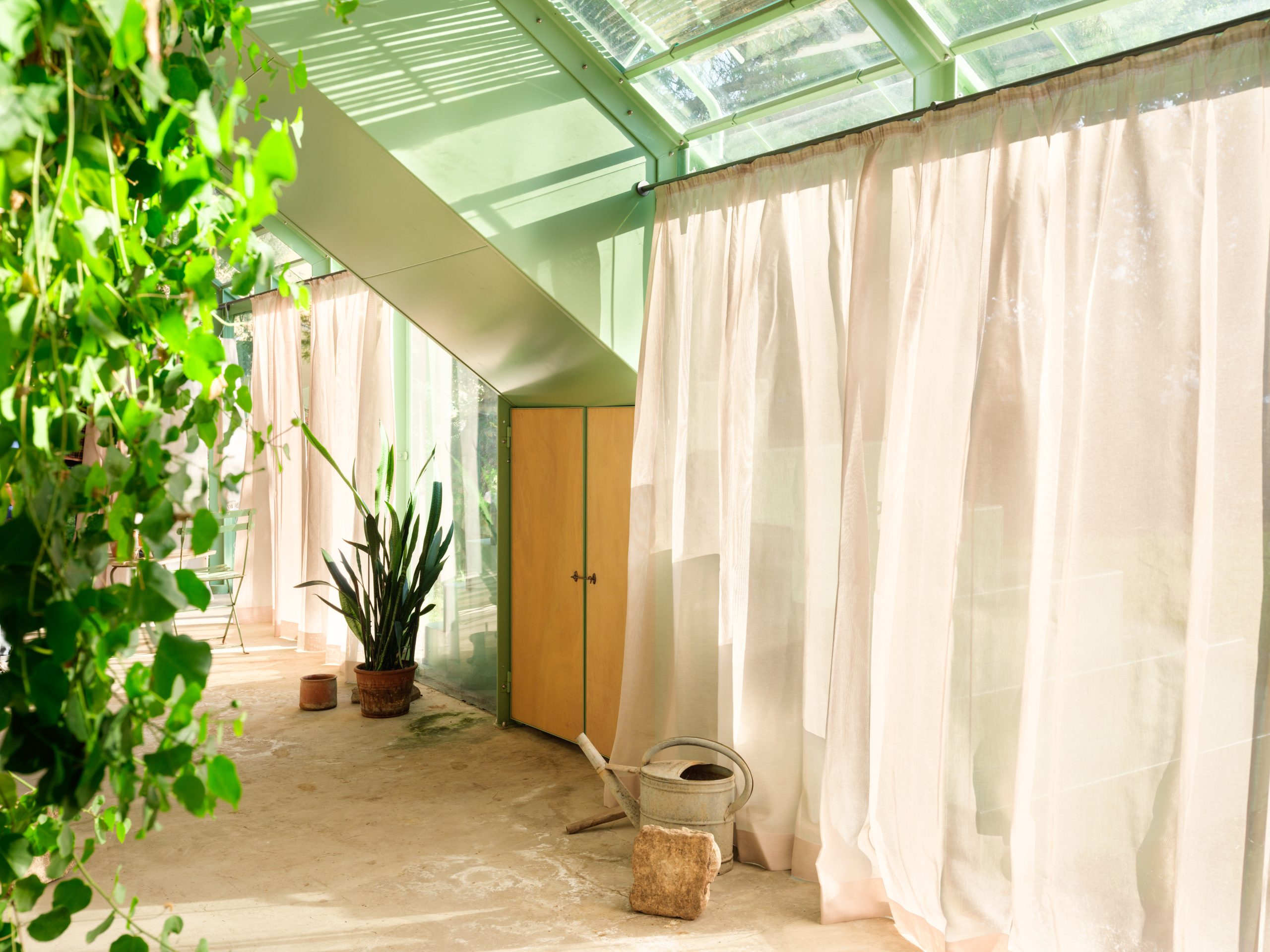 Stone, painted steel and glass composed within the garden