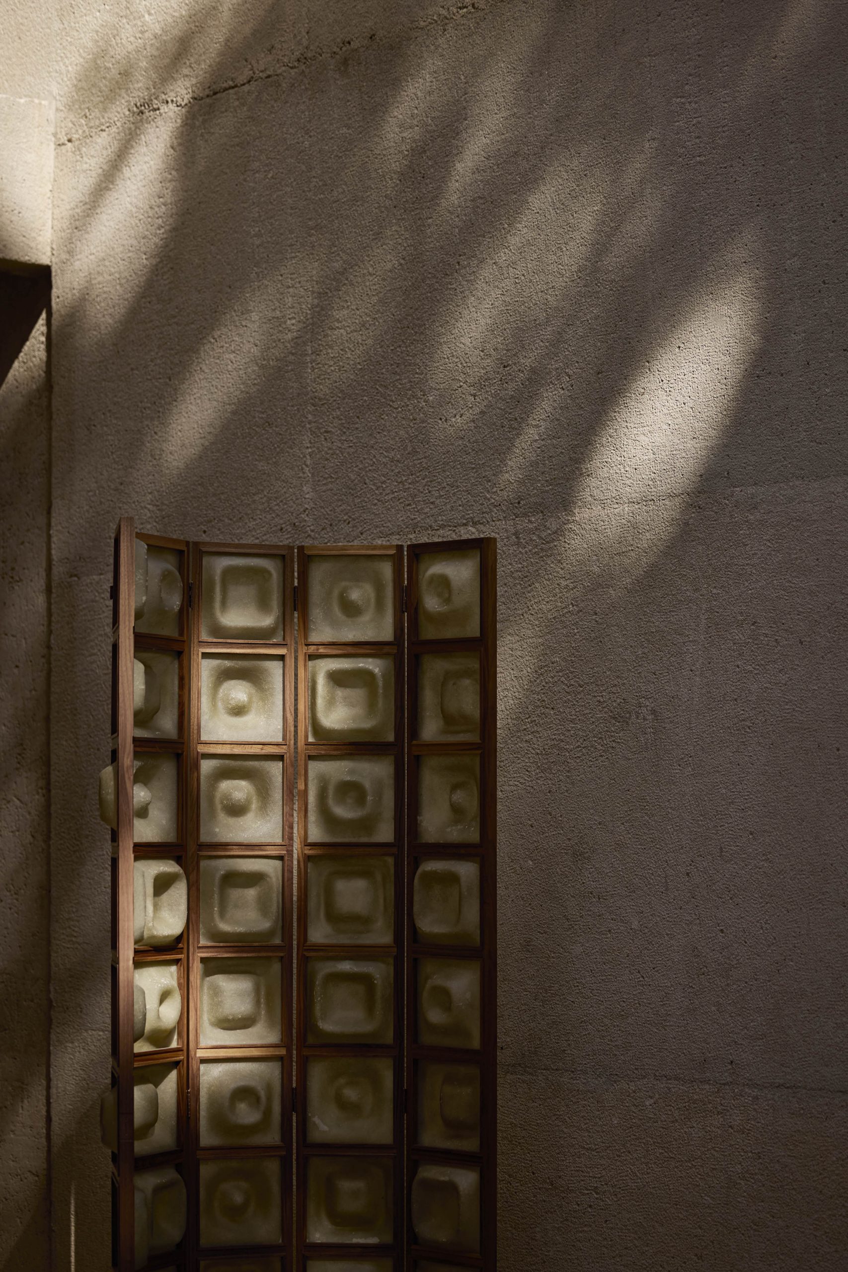 Glass-block screen casting shadows across the concrete interior of Casa Ínsula