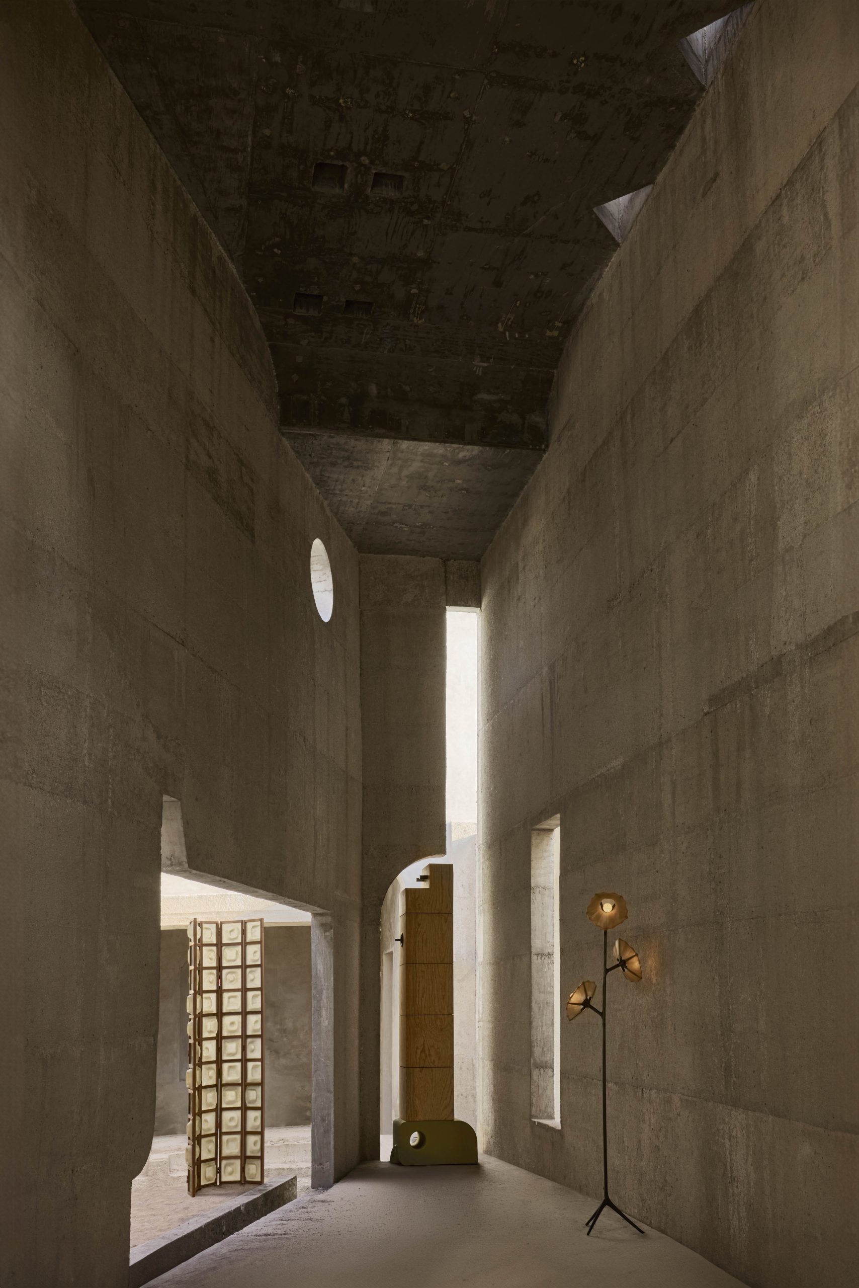 Long concrete passage illuminated by a roof opening at Casa Ínsula