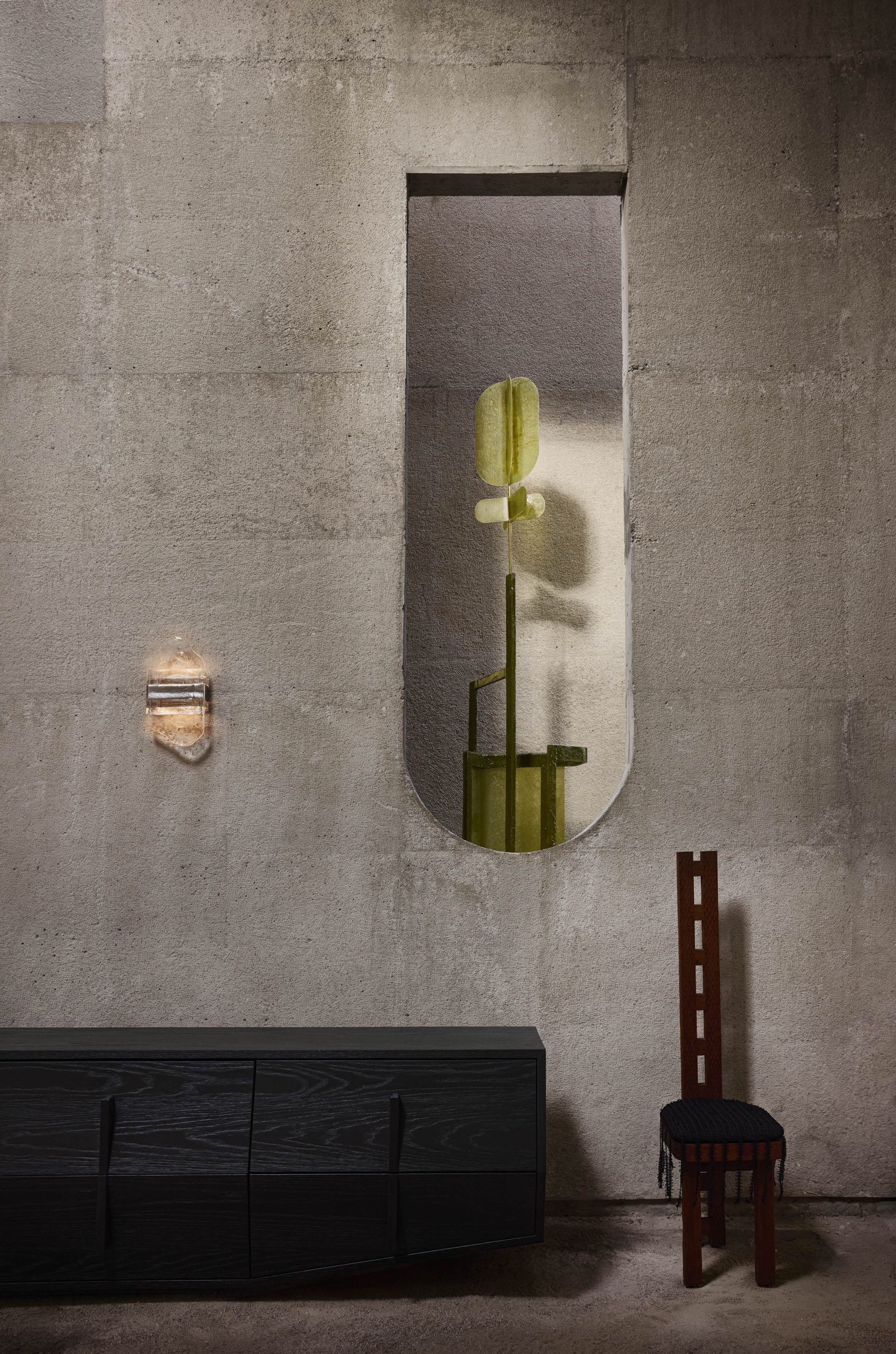 Green cactus and chair set against textured concrete at Casa Ínsula