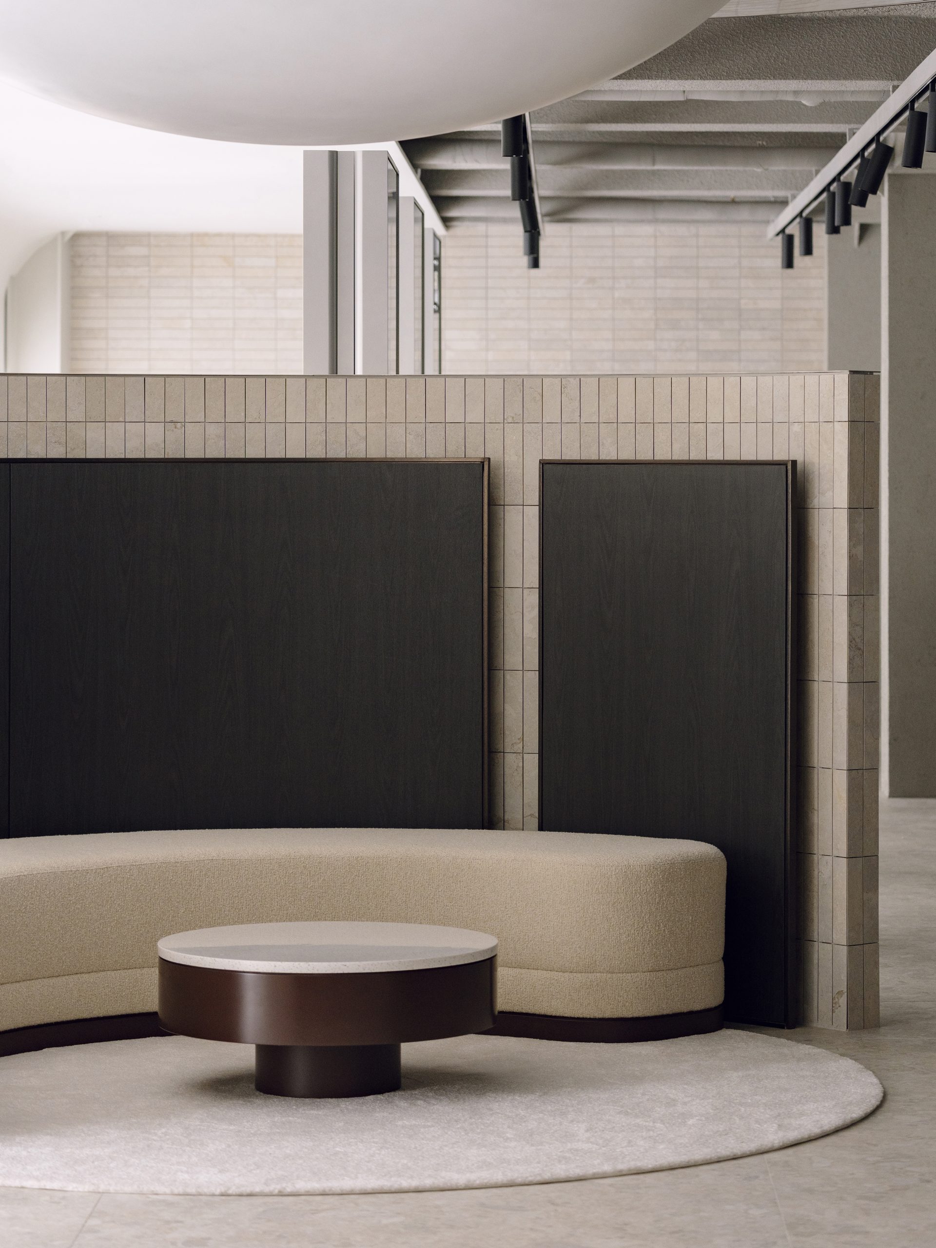 Circular sofa beneath reflective ceiling surfaces