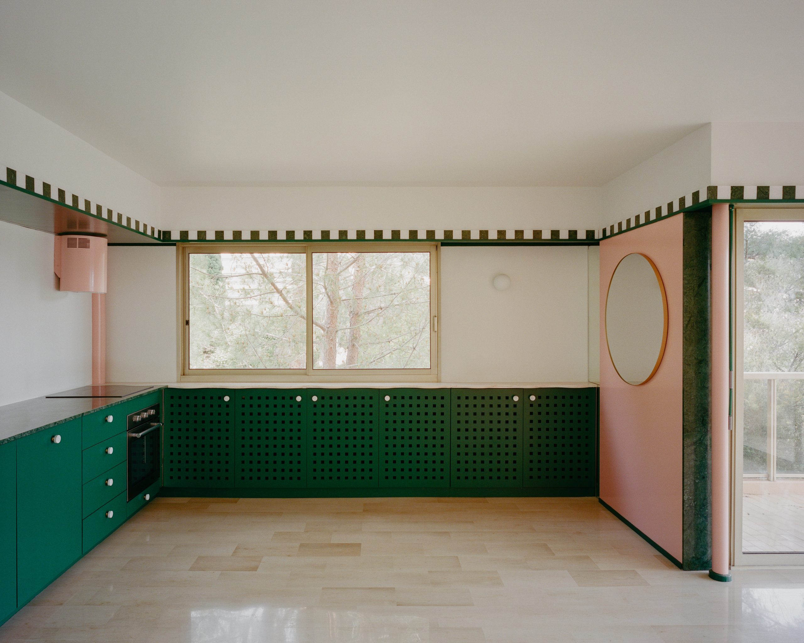 Cooking and dining area framed by striped surfaces in the Fabron apartment