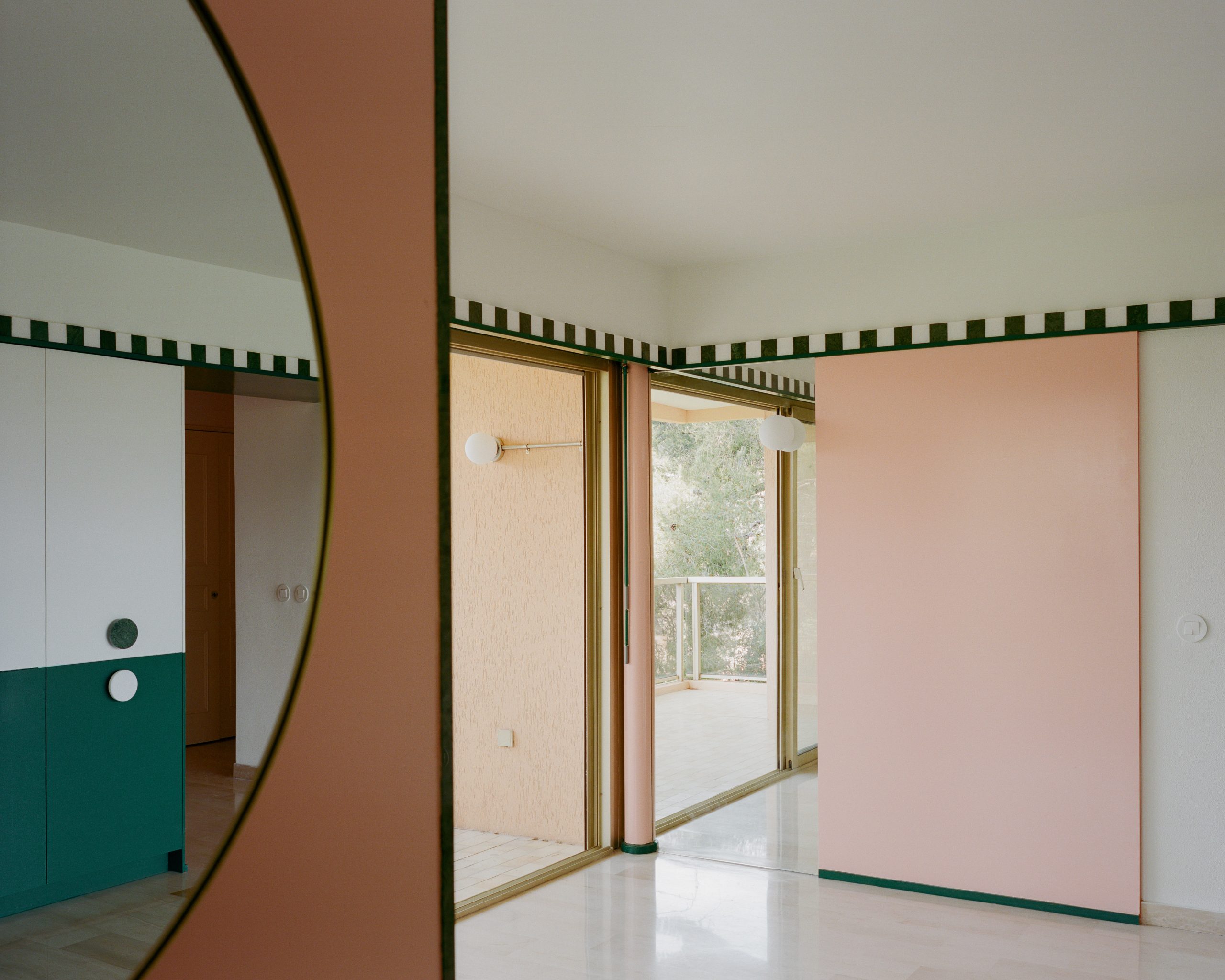 Apricot-coloured planes and deep-green cabinetry meet in the Fabron apartment living room