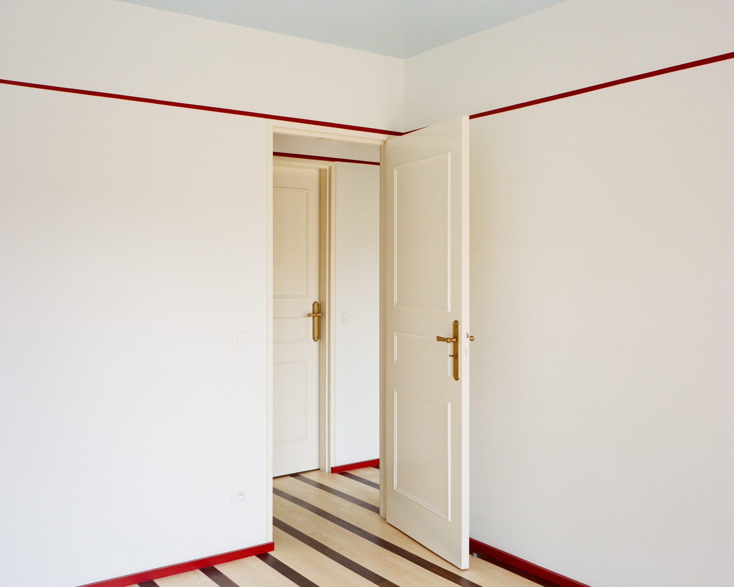 Bedroom enclosed by colour and reflective surfaces at the Fabron apartment