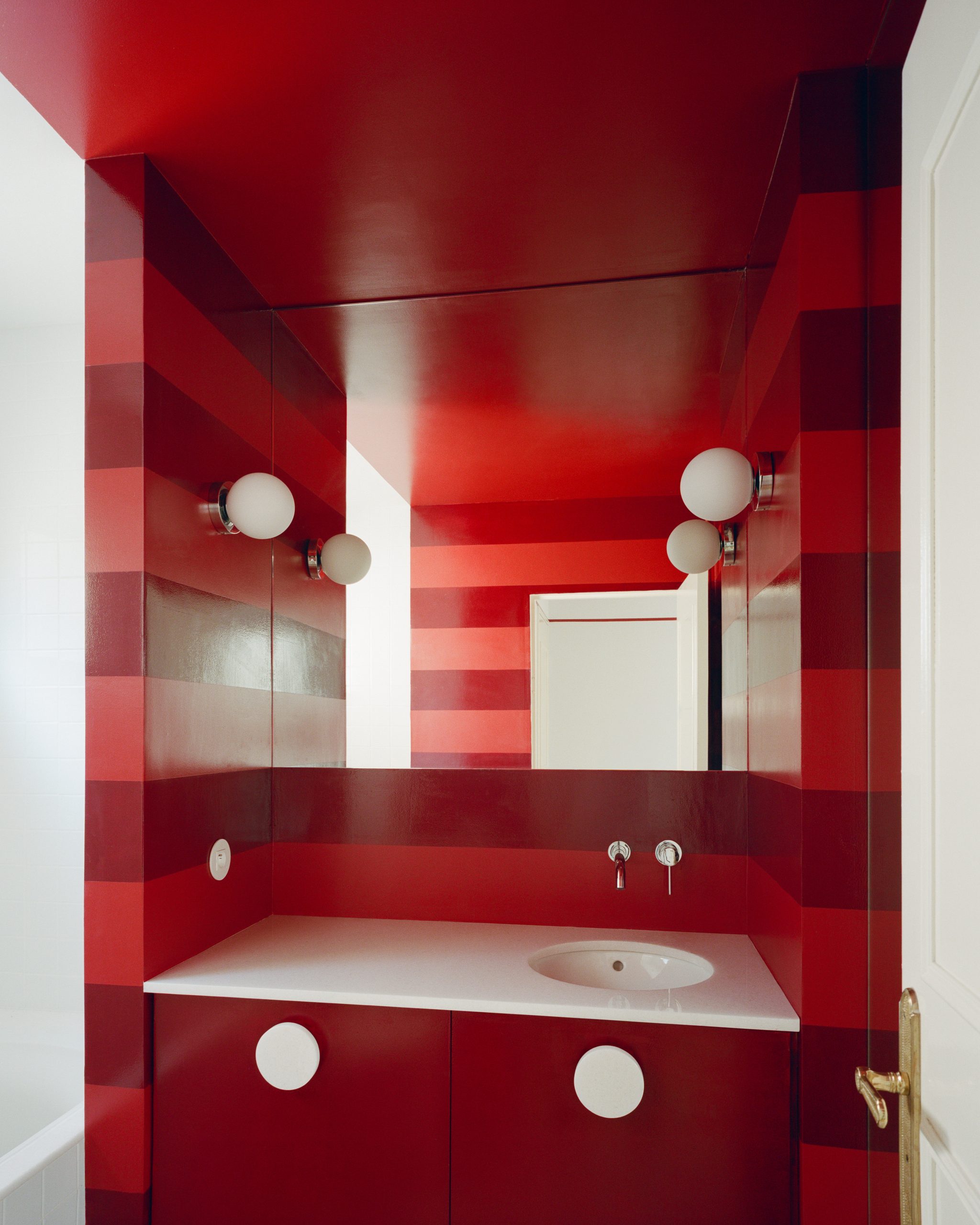 Bathroom shaped by coloured surfaces and mirrors at the Fabron apartment