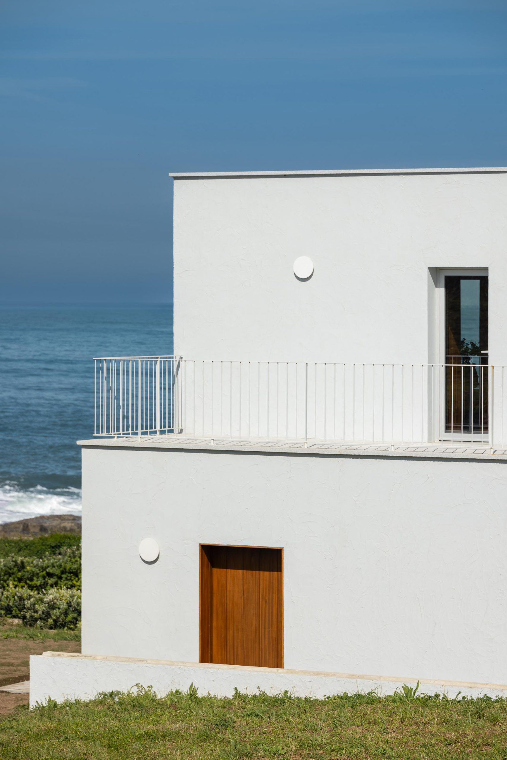 White rendered volumes of Casa Âncora among granite rocks