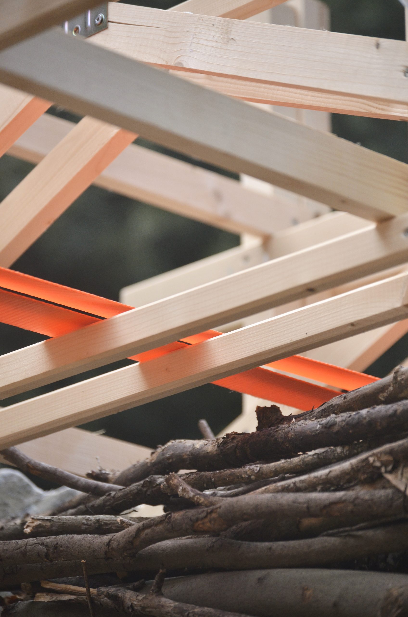 Timber members and orange straps form part of the exposed assembly.