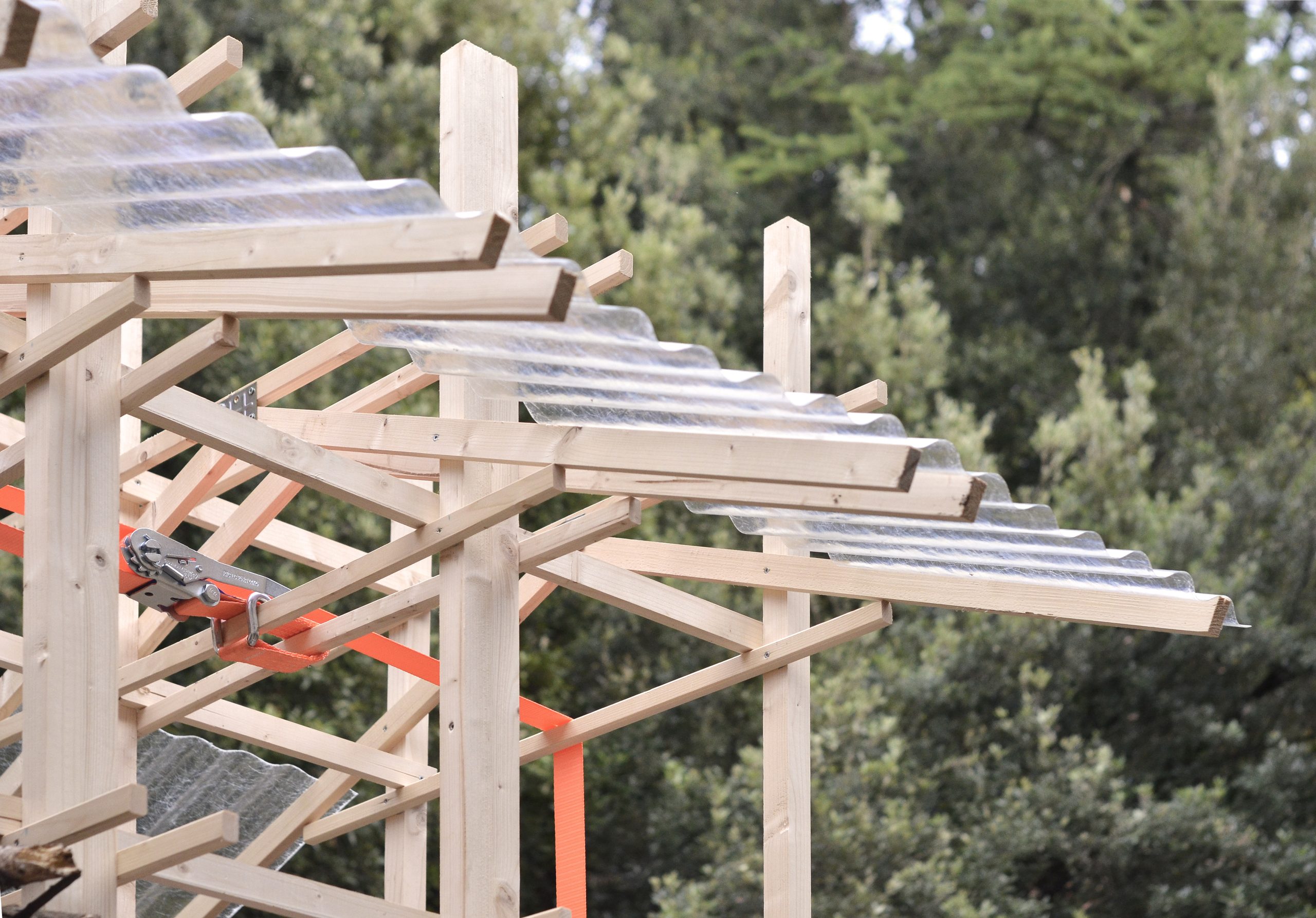 Corrugated roof panels extend beyond the timber frame.
