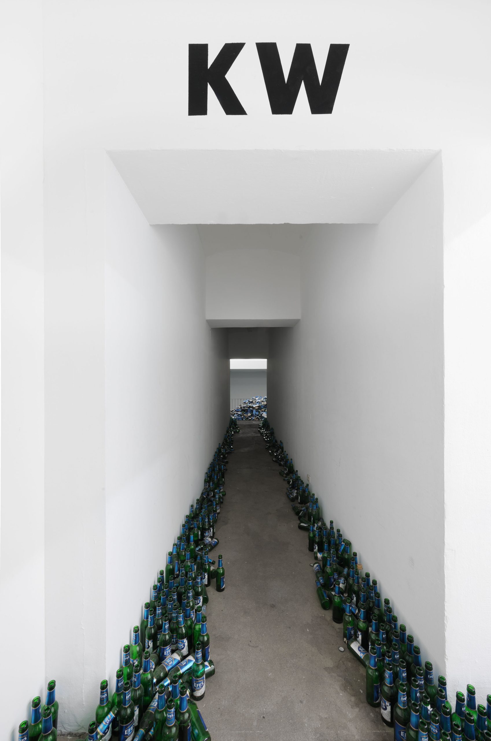 Bottles line the passage leading into the exhibition.