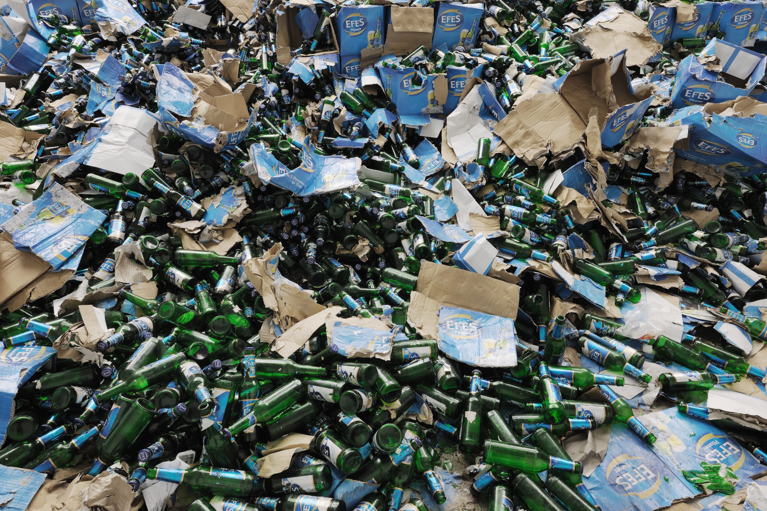 Bottles and damaged boxes accumulate in the installation.
