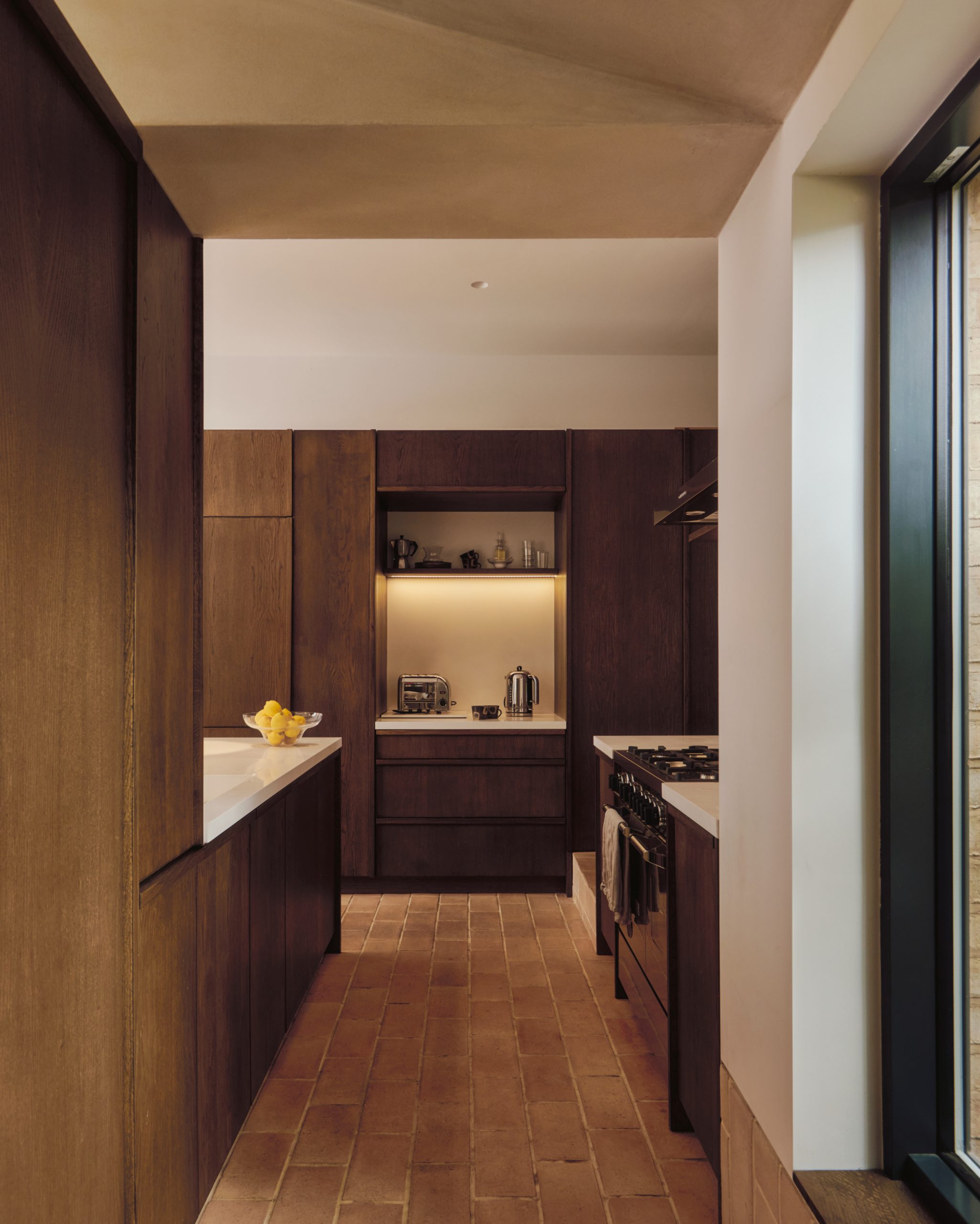 Dark-stained timber cabinetry lines the kitchen beside the courtyard.