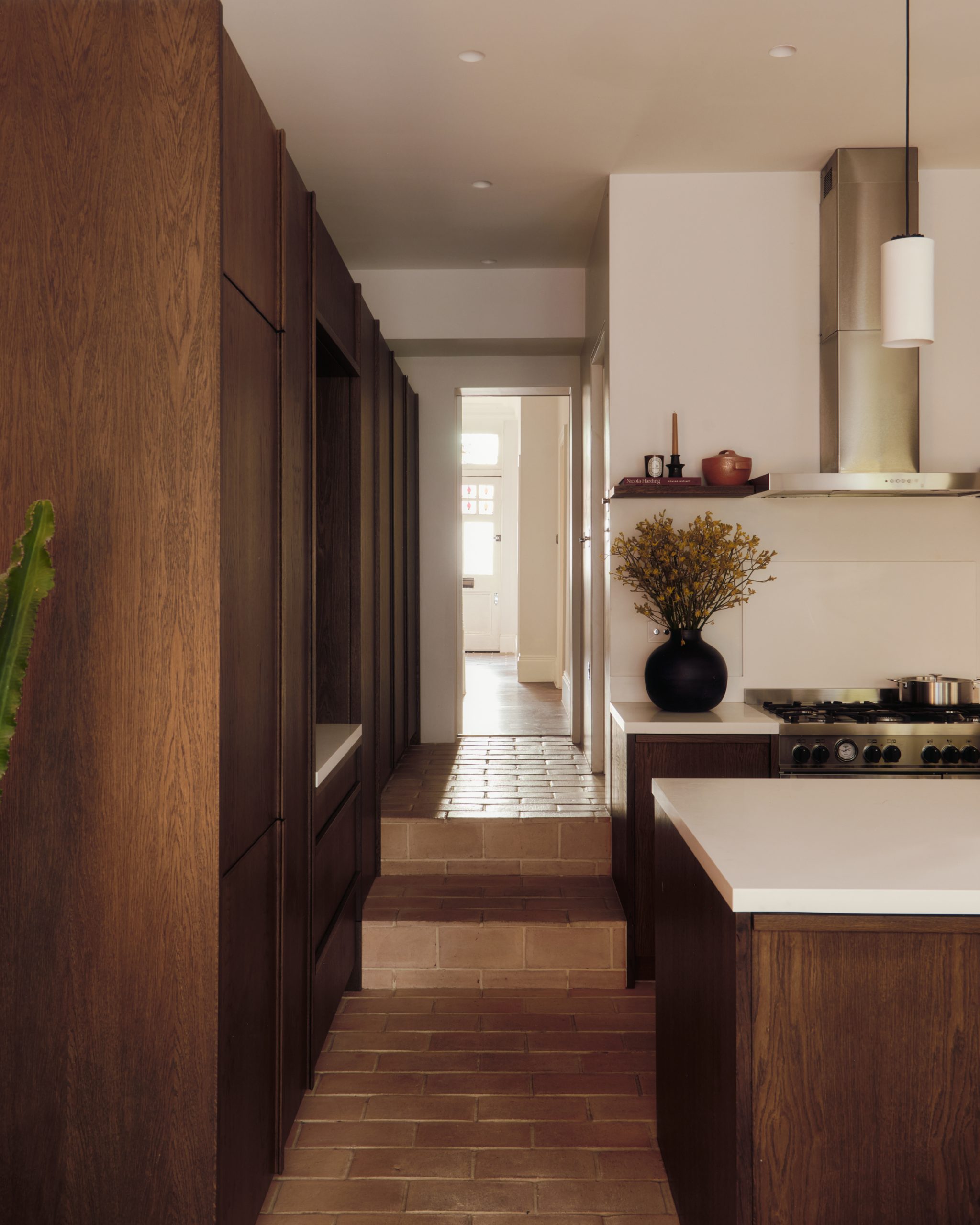 Openings in the joinery maintain views between the kitchen and adjoining spaces.