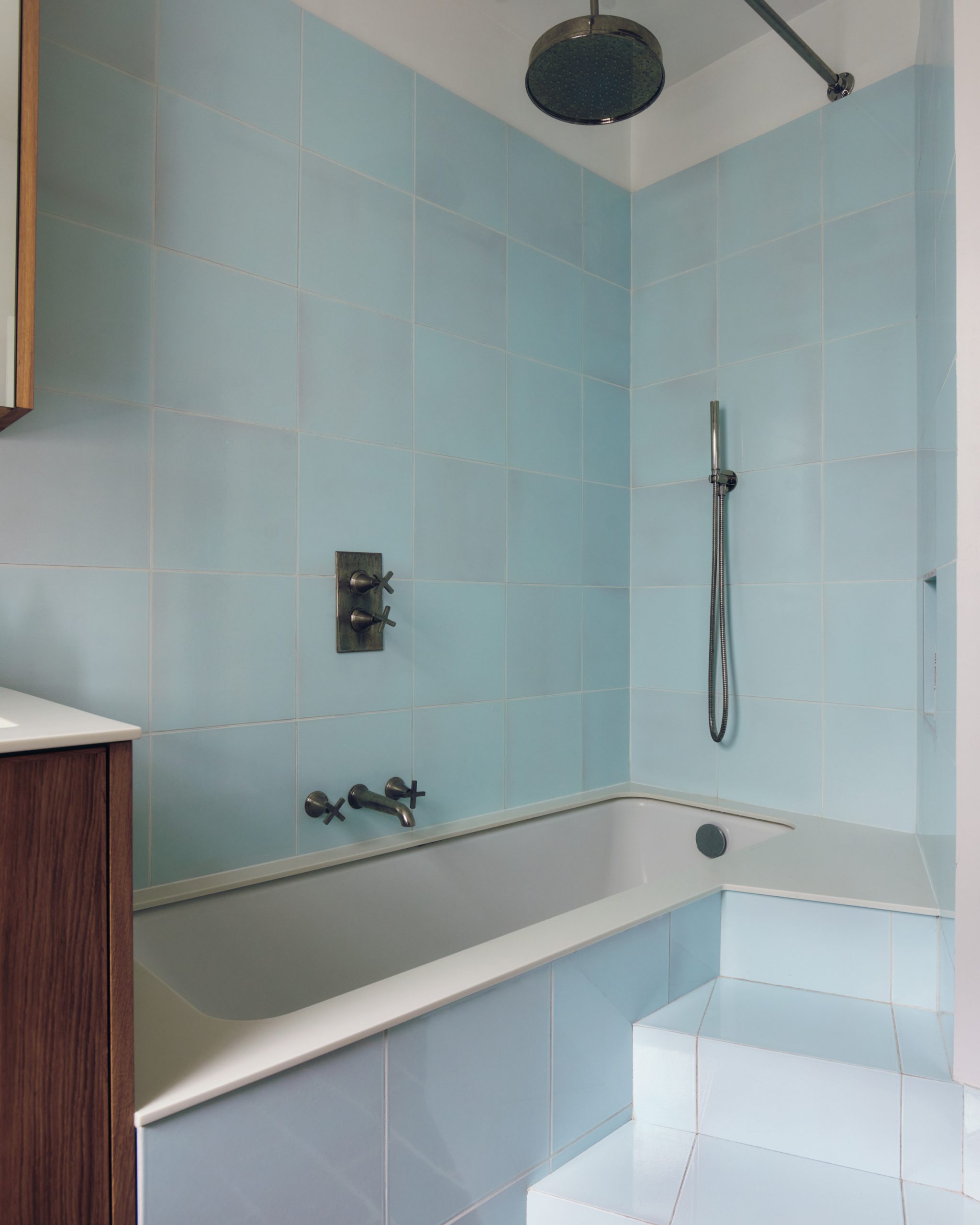 Sky-blue tiles line a stepped bath designed for family use.
